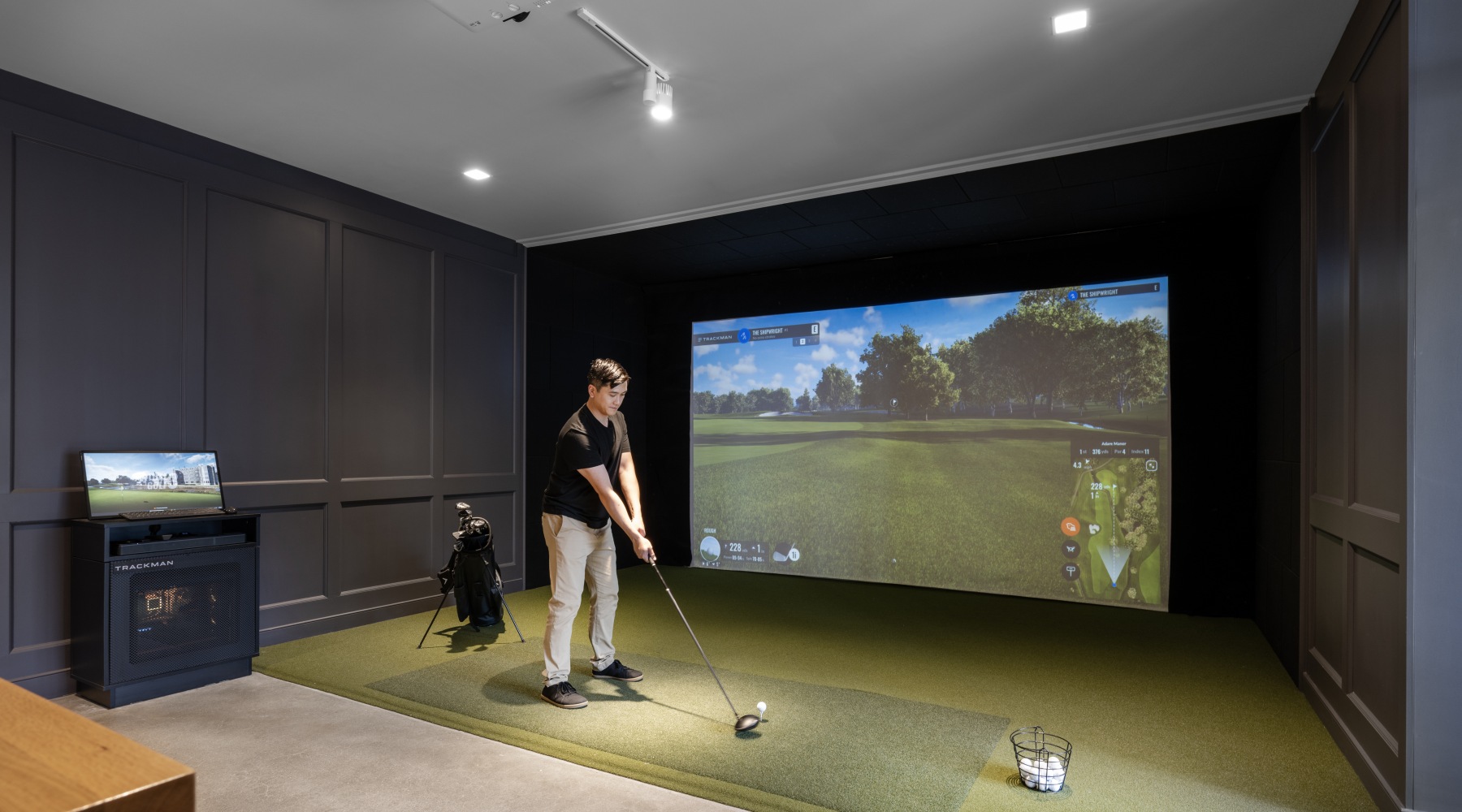 the shipwright golf simulator image image showing a man using the golf simulator at the shipwright apartments in lynn ma