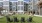 People playing cornhole and relaxing on Adirondack chairs in the picnic retreat lawn at The Shipwright apartments in Lynn, MA, surrounded by modern apartment building